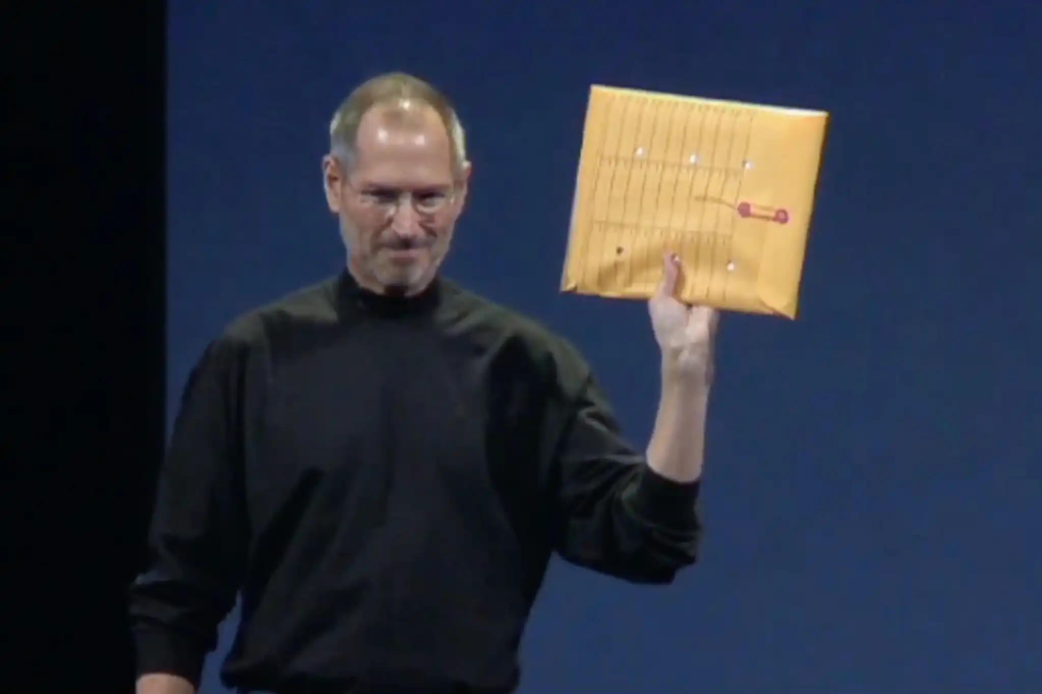 Steve Jobs with an envelope including the first Macbook Air